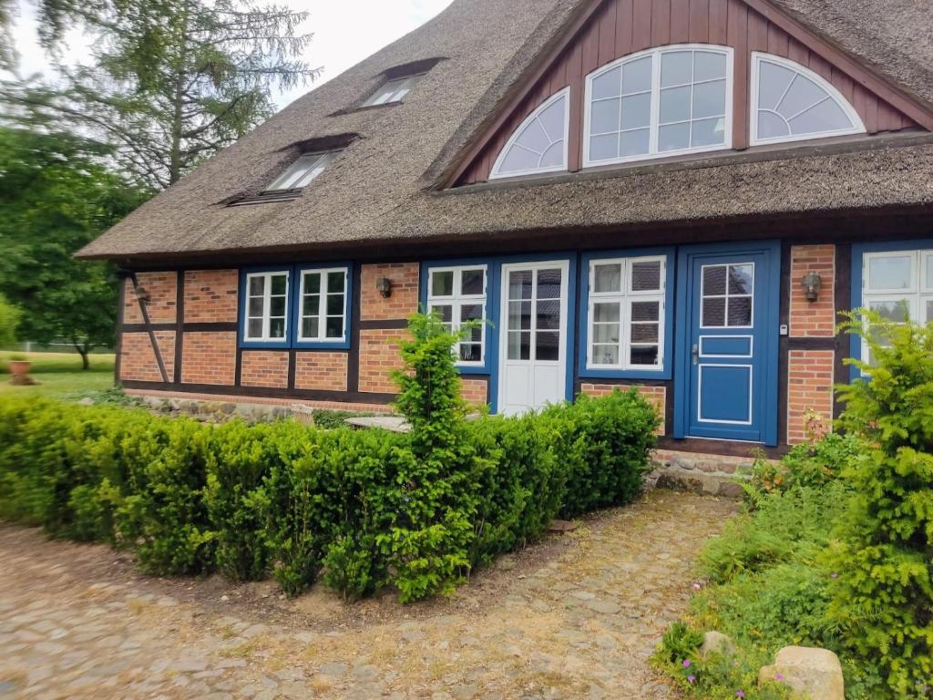 格雷沃斯米伦Chalet Forsthof Everstorf - kleine Wohnung的一座带蓝色门和灰色屋顶的房子