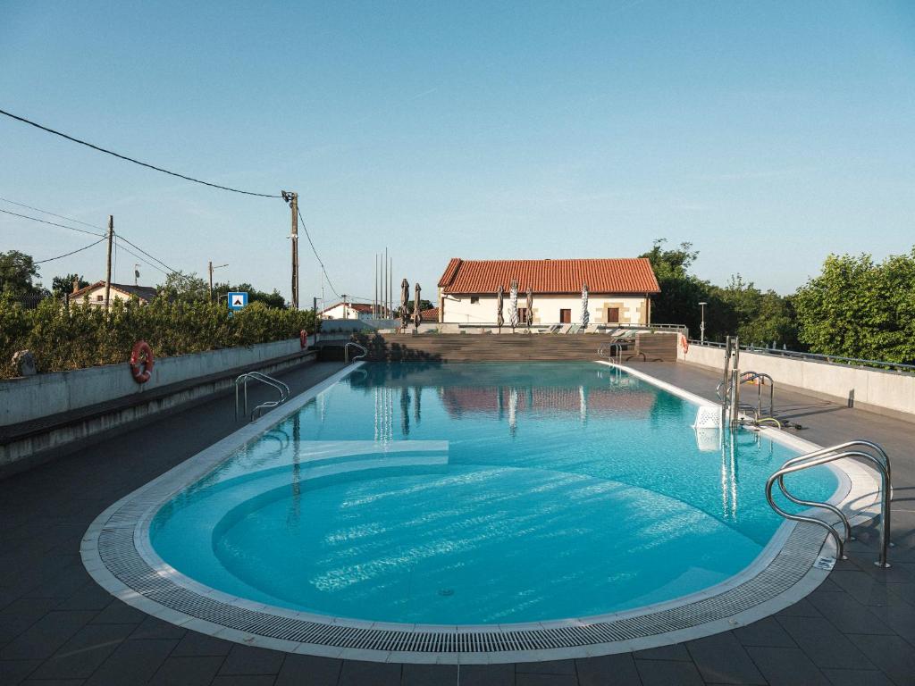 圣塞瓦斯蒂安Wecamp San Sebastián的一座大型游泳池,后面有一座房子