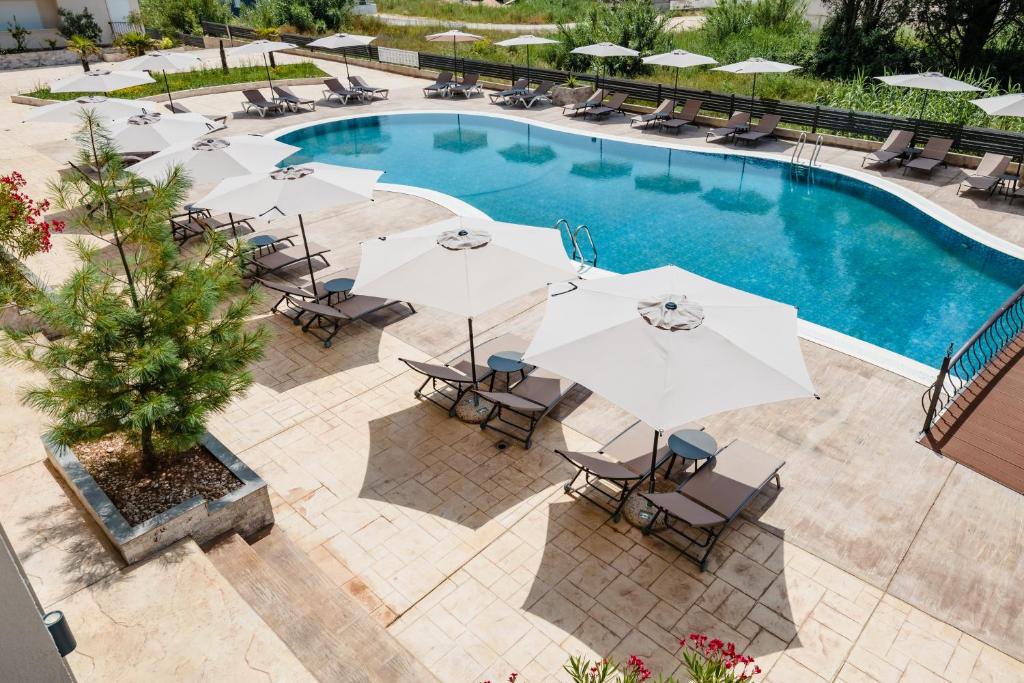乌尔齐尼Hotel Olea的享有带遮阳伞和椅子的游泳池的顶部景致