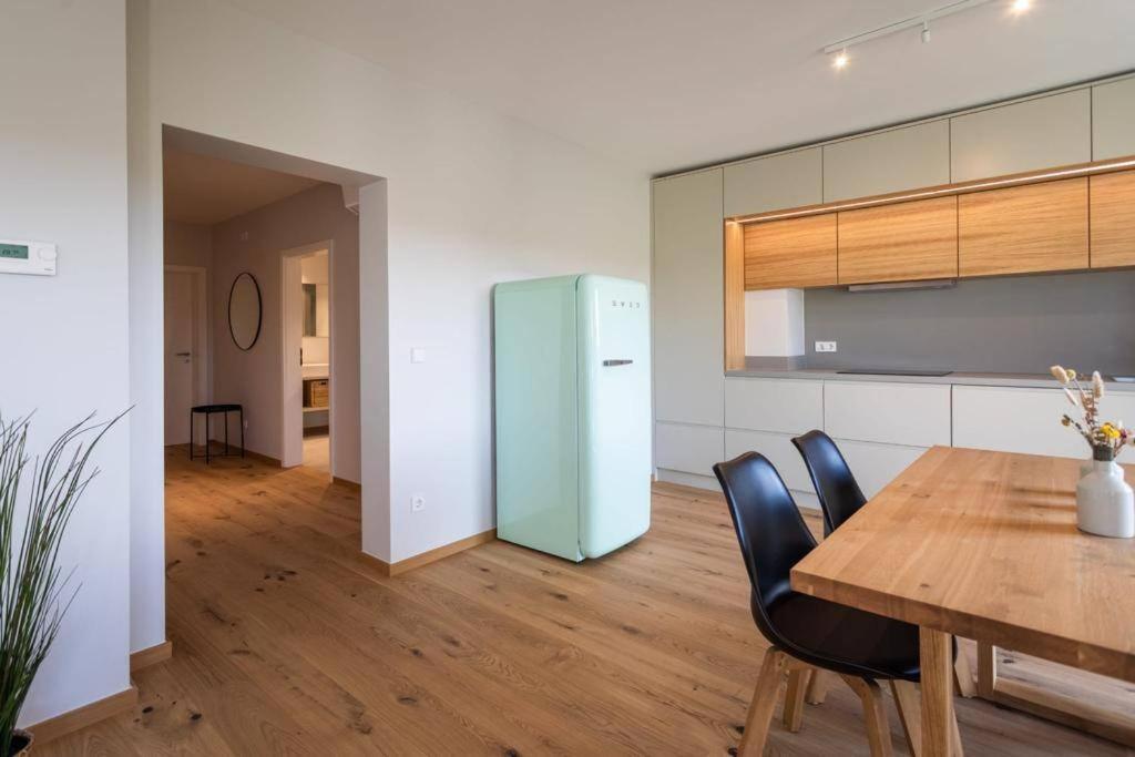 卢森堡Renovated 2 Bedroom Apartment with Parking & AC的厨房配有木桌和冰箱。