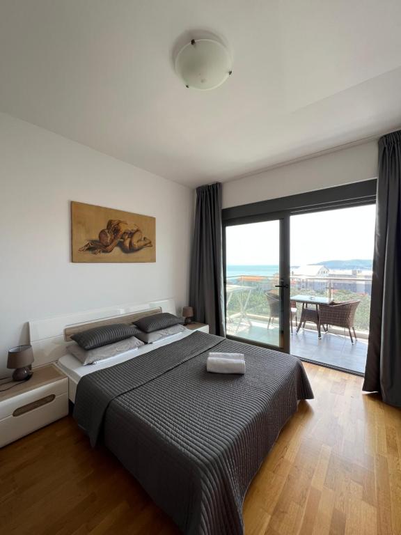 贝西奇Paradise Apartments Becici的一间卧室设有一张大床和一个大窗户