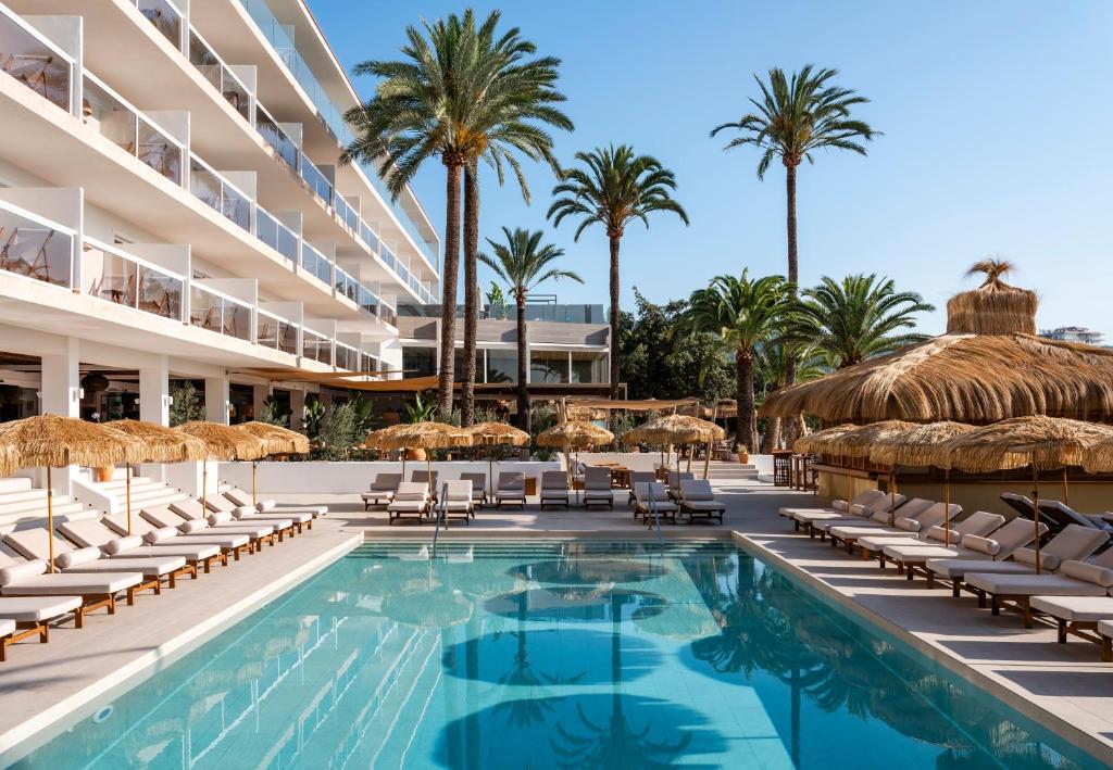 帕尔马诺瓦Zel Mallorca的一个带椅子和遮阳伞及棕榈树的度假游泳池