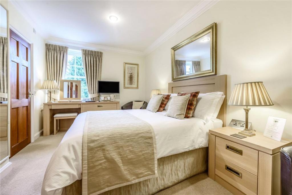 拜伯里Cotteswold House的一间卧室配有一张大床和一张书桌