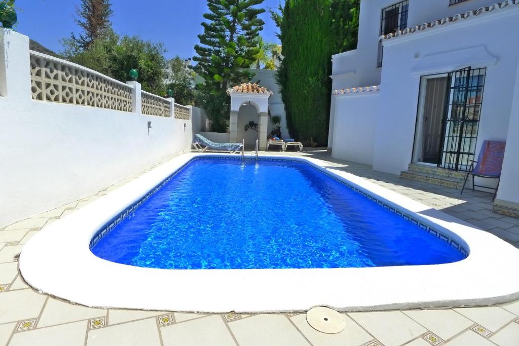 内尔哈Villa Golondrinas - Private villa to sleep 6的白色房子前的游泳池