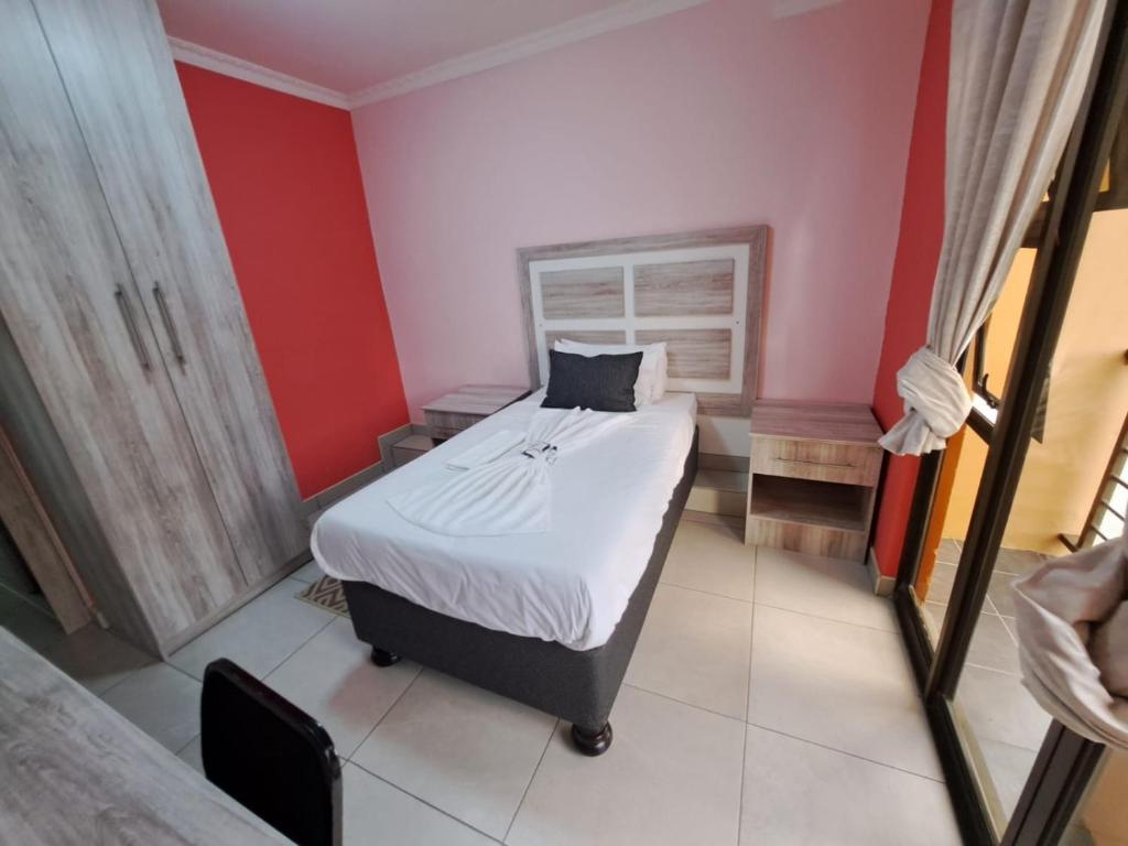 马塞卢Jate Guest House的一间卧室设有一张床和红色的墙壁