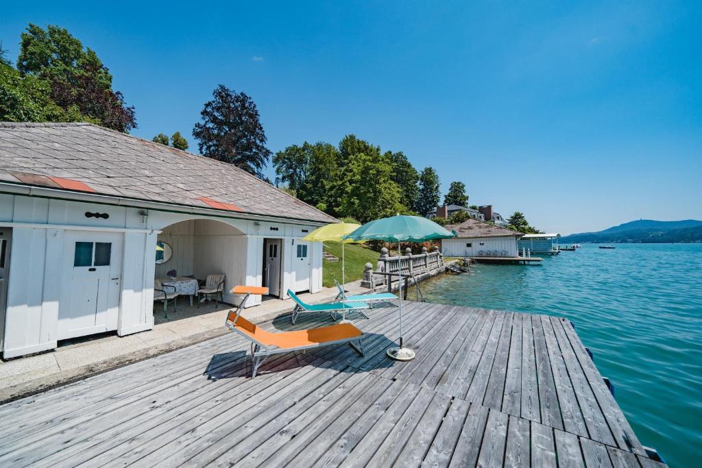 沃尔特湖畔韦尔登Villa Fernblick的一个带两把椅子和一把雨伞的码头