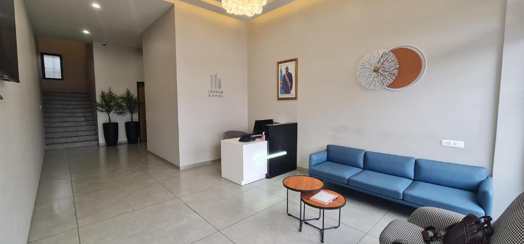 金沙萨Ixoras Hotel Lemba的一间设有蓝色沙发和桌子的等候室