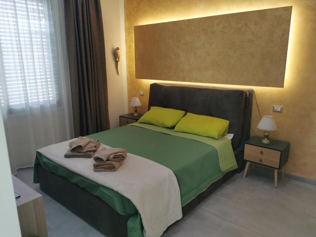 蒙特西尔瓦诺L'Anfora的一间卧室配有绿床和毛巾