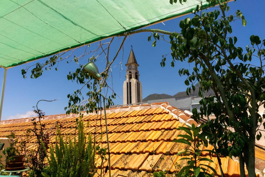 埃尔帕索Hostel Albergue La Casa Encantada的享有建筑背景中钟楼的景色