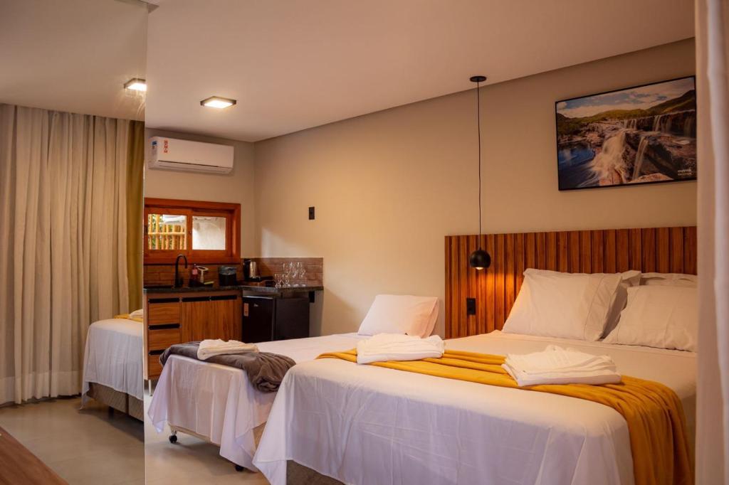 穆库热Vila Diamantina的酒店客房设有两张床和盥洗盆