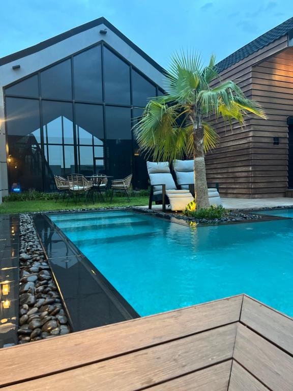 布赖代شاليه كوتج的一座房子前面的游泳池,上面有棕榈树