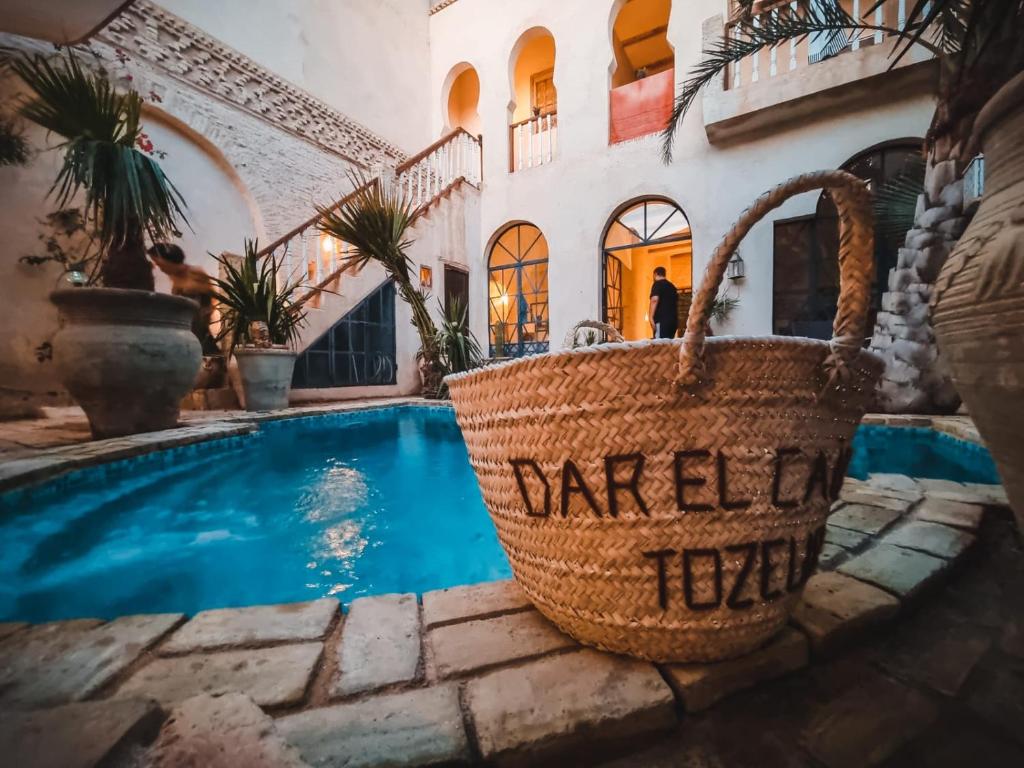 托泽尔Riad Dar El Caid - Palais XIII Siecle的一座房子,设有游泳池和地板上的篮子