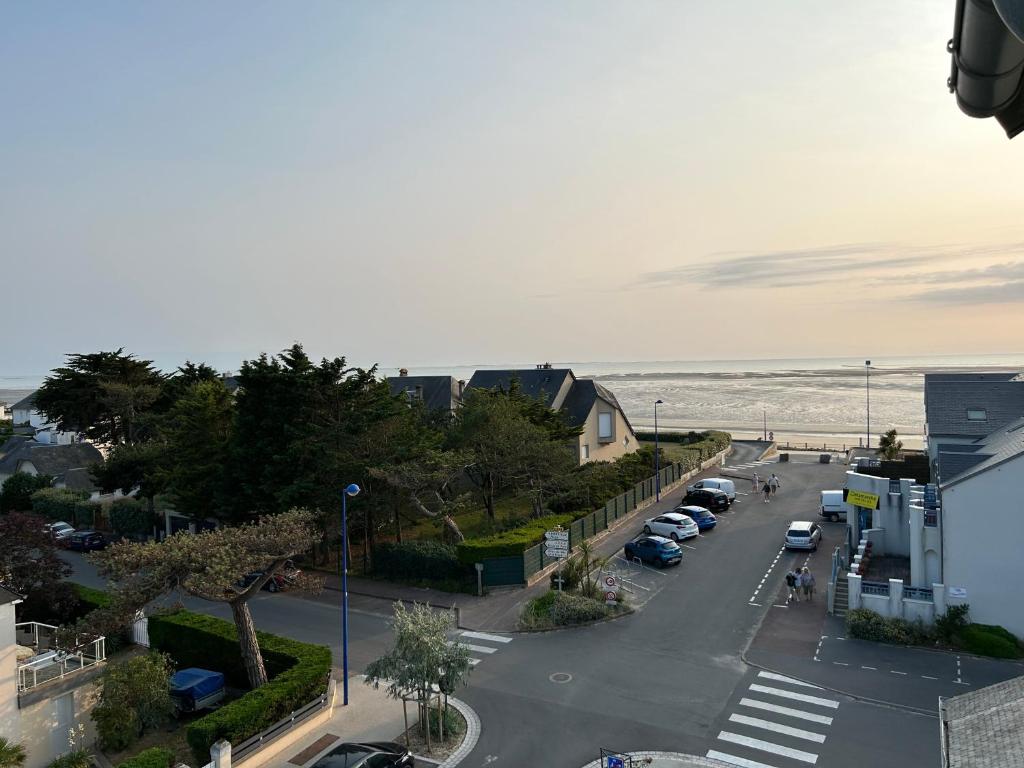 Hauteville-sur-MerAppartement pour évasion marine à Hauteville sur mer的享有街道的景色,海滩上设有停车位