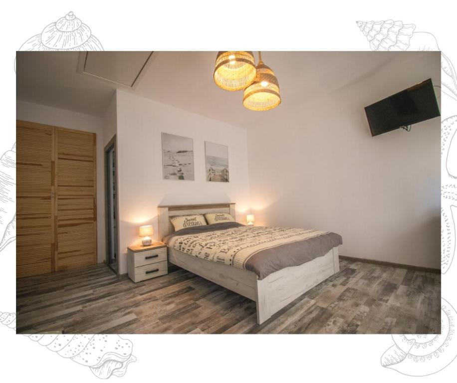 瓦杜Flip Flop Bungalows的一间卧室配有一张床、一台电视和灯