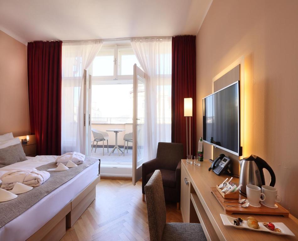 布拉格阿马里亚特杰罗姆酒店的酒店客房配有一张床和一张书桌及一台电视