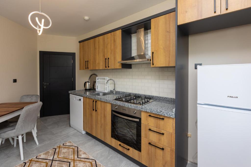特拉布宗Moonlight Suite Hotel的厨房配有木制橱柜和白色冰箱。