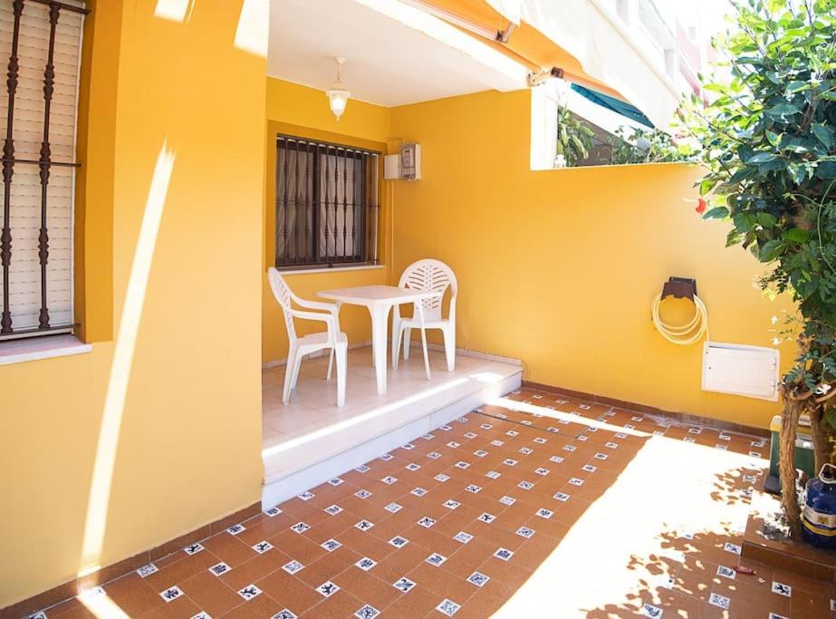 桑卢卡尔-德巴拉梅达SibsSanlucar Albero - Ideal Familias - Centro - Playa Piletas的天井配有桌椅和黄色墙壁