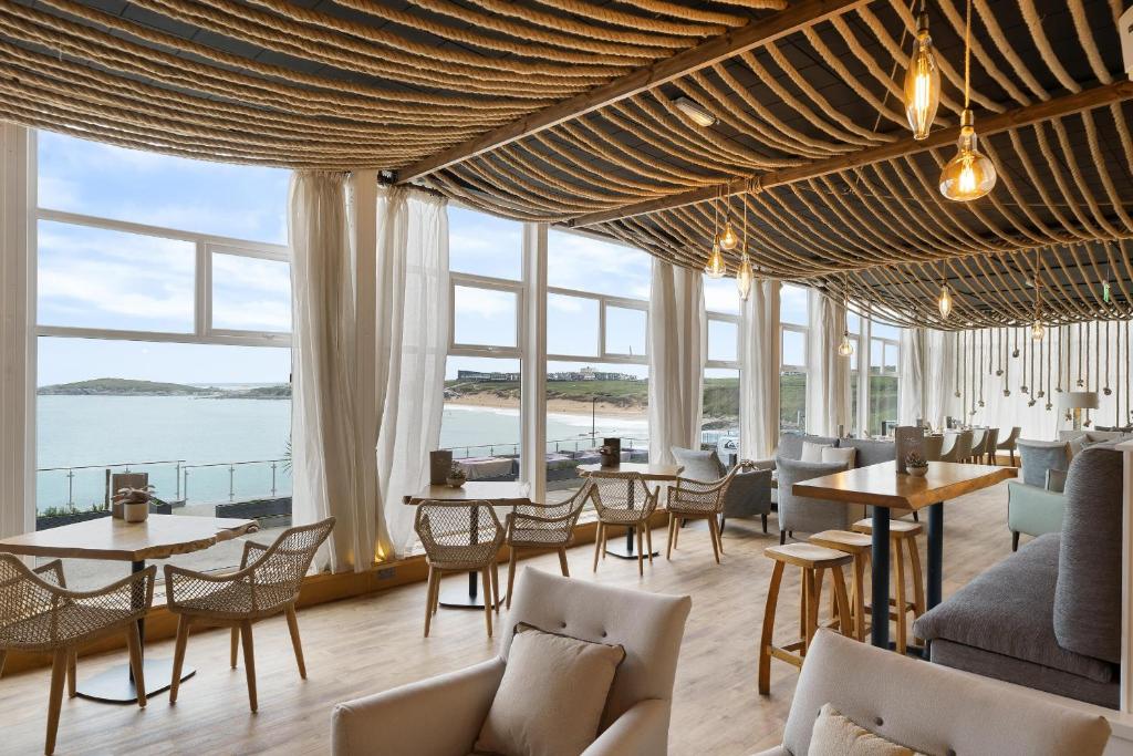 纽基菲斯特拉尔海滩酒店及Spa - 仅限成人入住的餐厅设有桌椅和大窗户。