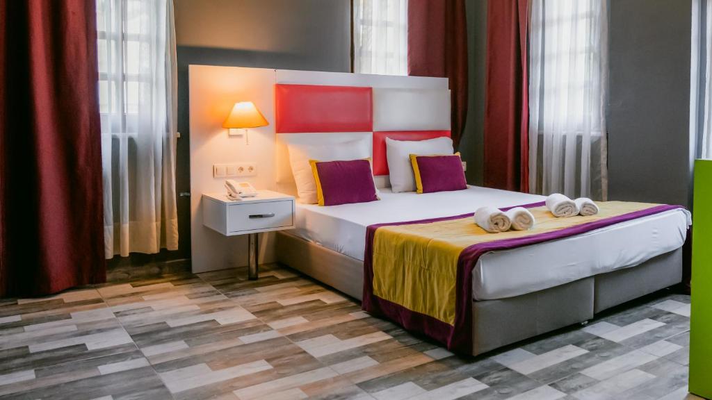 安塔利亚Orange Owl Hotel的酒店客房,配有带毛巾的床