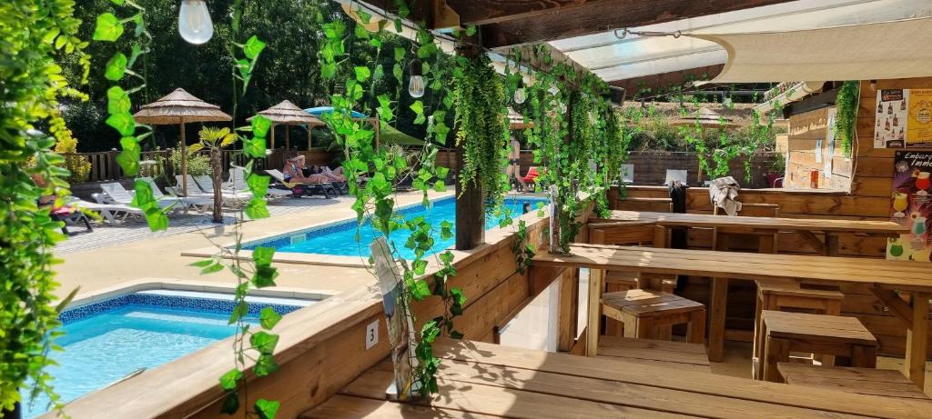 吕奥姆卡彭蒂露营地的一个带游泳池、桌子和植物的餐厅