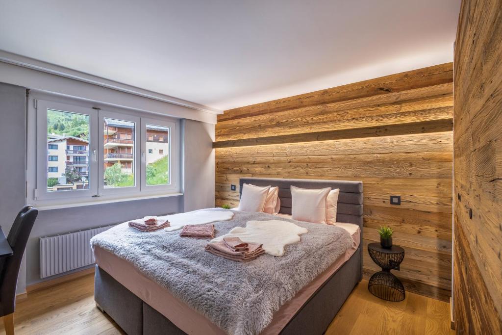 洛伊克巴德Lucky Fox的一间卧室设有一张带木墙的大床