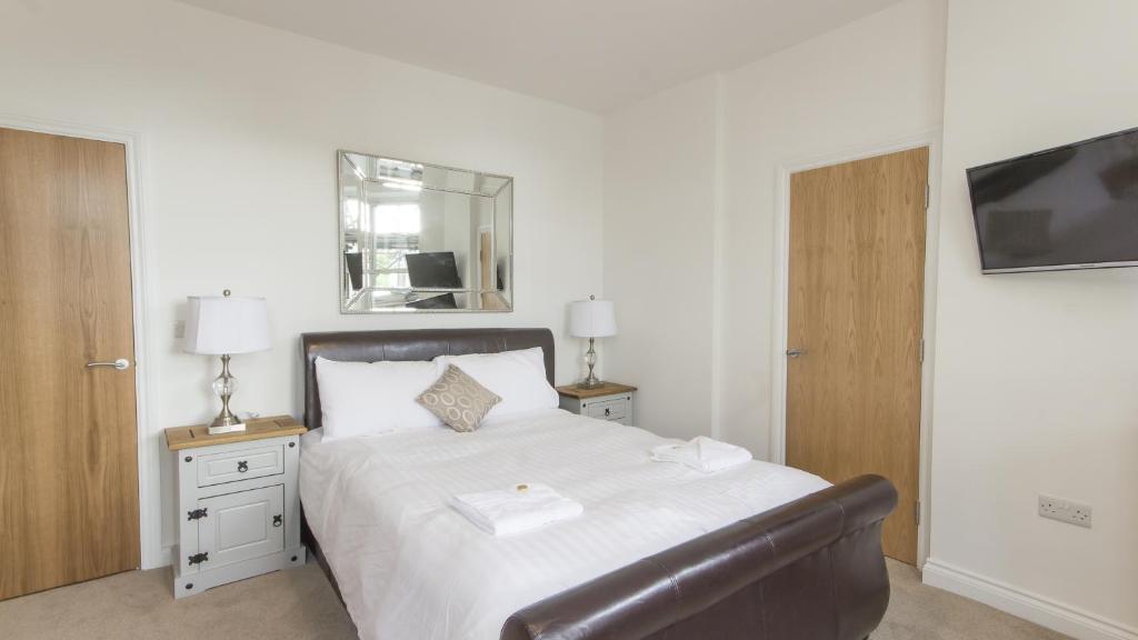 普里茅斯3 Bed Edenhurst By Pureserviced的一间卧室配有一张带椅子和镜子的床