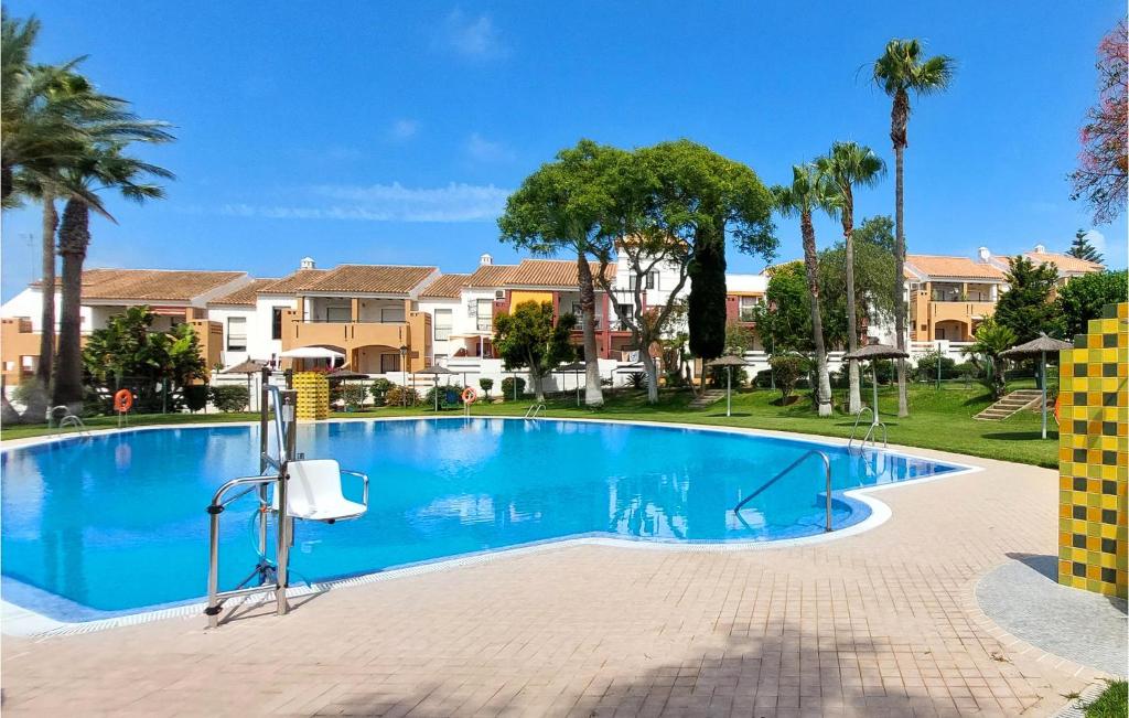 诺沃桑克蒂佩特里Cozy Apartment In Chiclana De La Front, With Outdoor Swimming Pool的棕榈树别墅内的游泳池