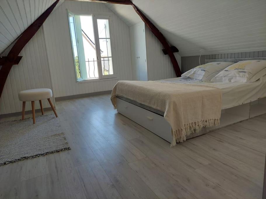吕讷Le Cadran的阁楼卧室配有床和椅子