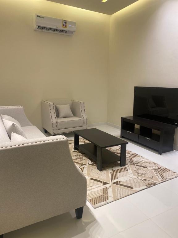 塞拉莱Rateel Apartments的带沙发、电视和桌子的客厅