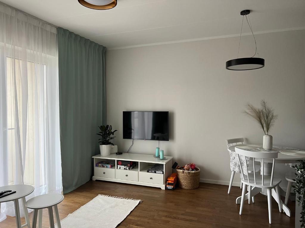 塔尔图Apartment Kvartsi的客厅配有电视和桌椅