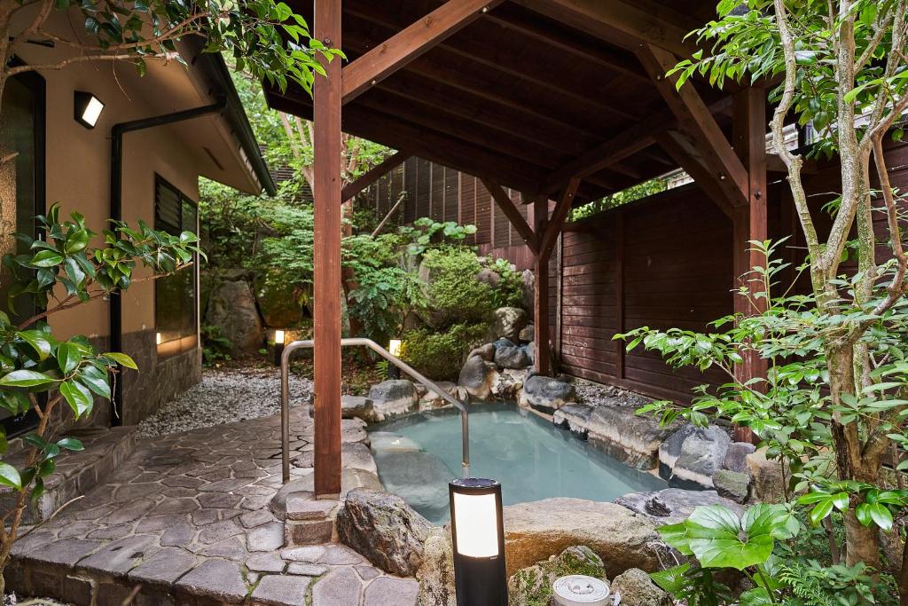 箱根Ajisai Onsen Ryokan的花园内的小游泳池,设有喷泉