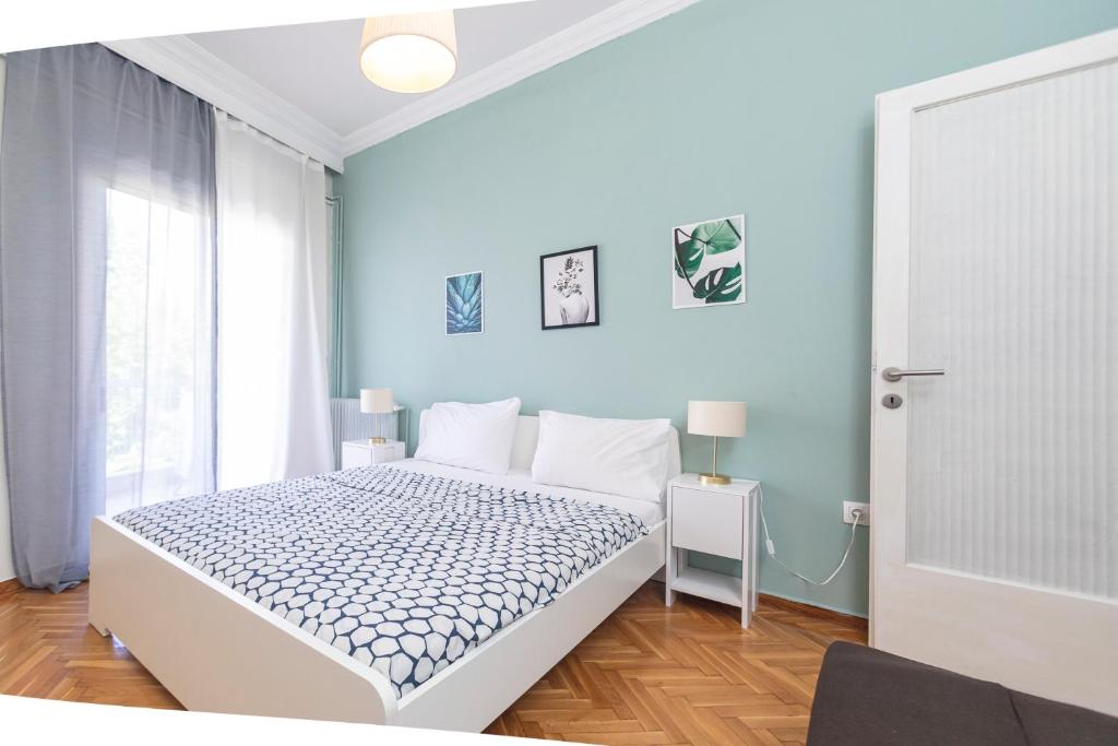 塞萨洛尼基Houseloft Bianca Vision的卧室配有白色的床和蓝色的墙壁