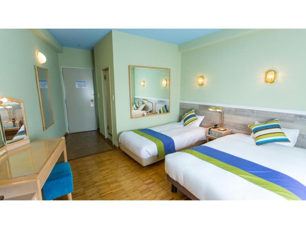 境港市Hotel AreaOne Sakaiminato Marina - Vacation STAY 81704v的酒店客房配有两张床和一张书桌