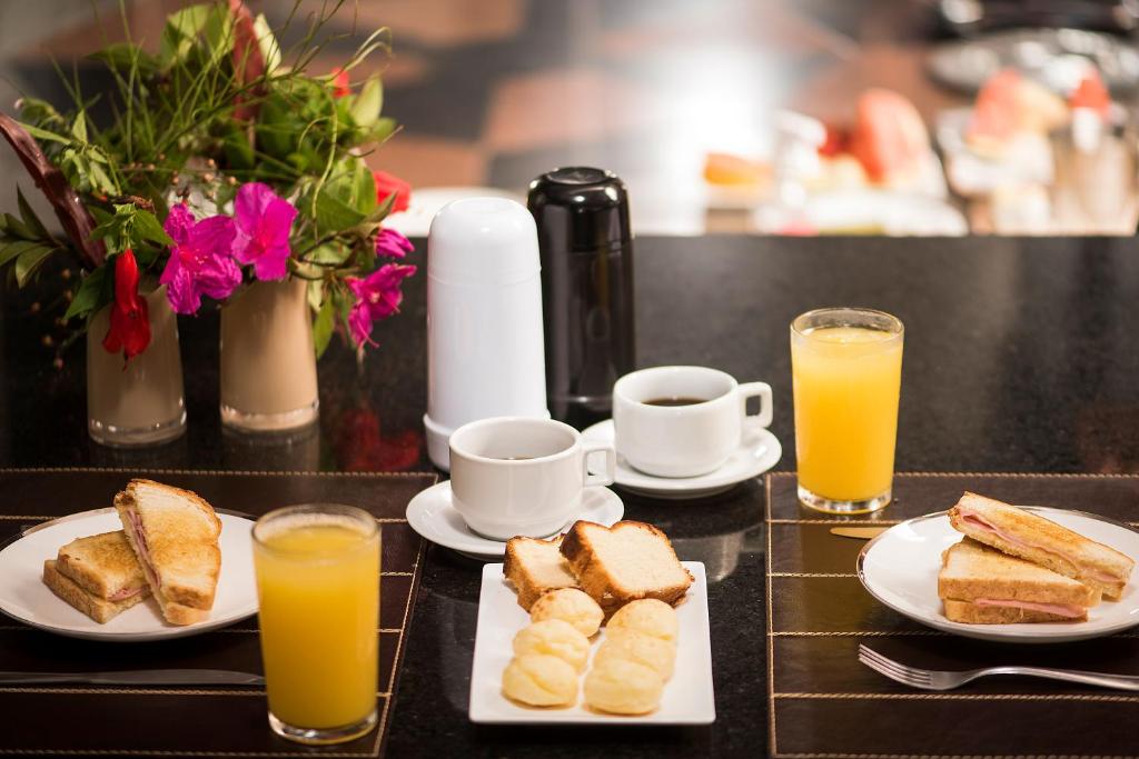 贝洛奥里藏特STATUS Motel的一张桌子,上面放着烤面包片和两杯橙汁
