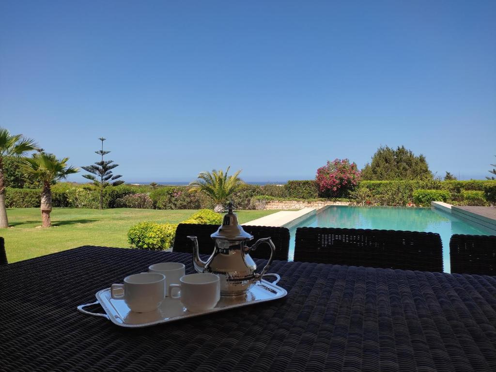 索维拉Villa Golf de Mogador - Piscine - Vue mer 180º的茶几,咖啡杯,茶壶