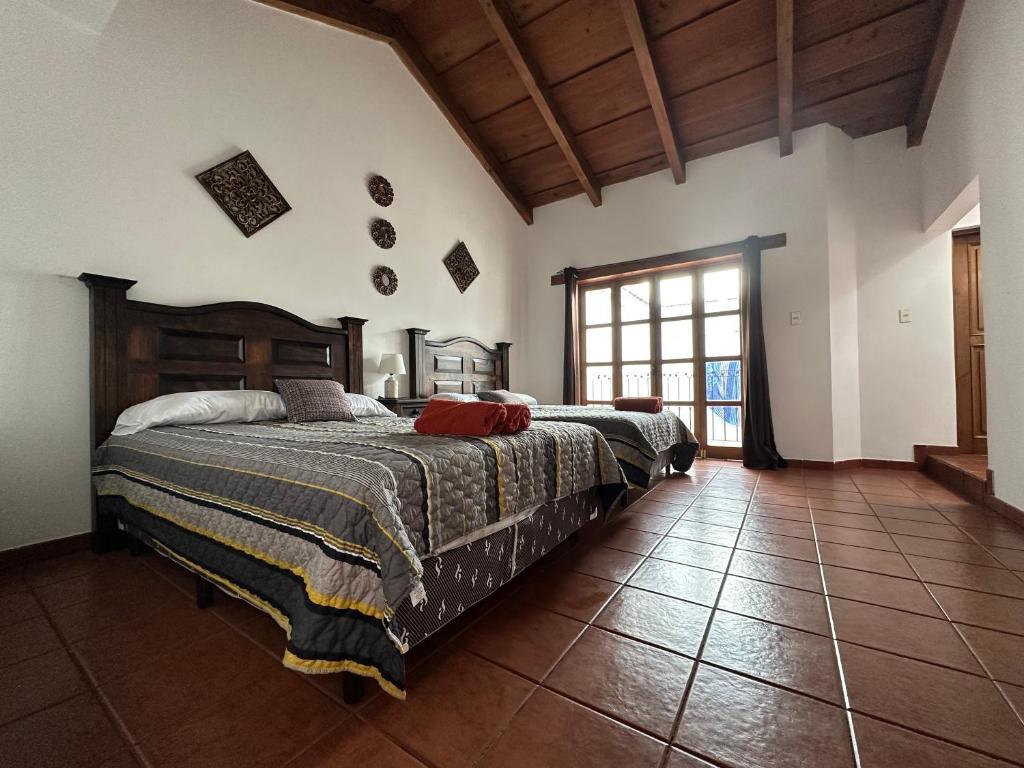 危地马拉安地瓜Casa Los Habitantes Antigua Guatemala的一间卧室设有两张床和大窗户