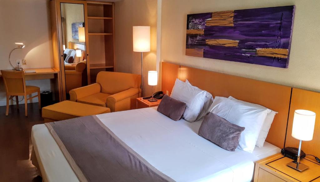 索罗卡巴卡登姆酒店的配有一张床和一把椅子的酒店客房