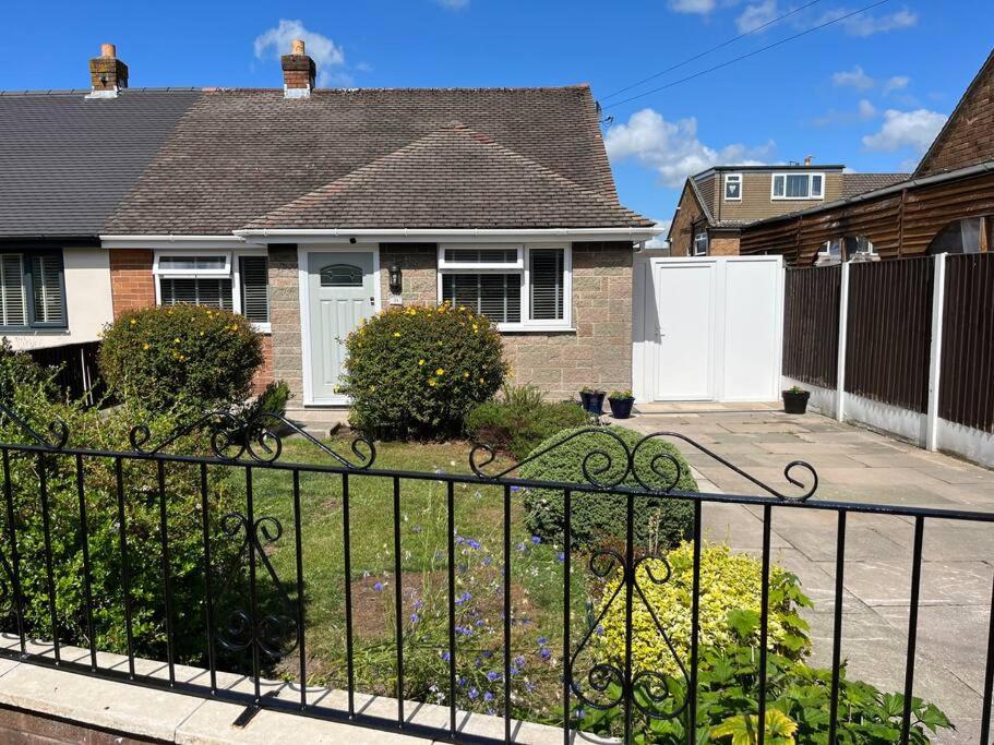 BurscoughIdyllic bungalow, ideal location in West Lancashire的院子前有围栏的房子