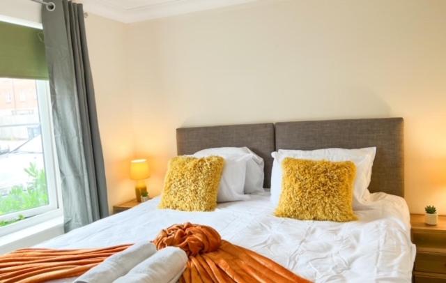 梅尔克舍姆Turners Court的一间卧室配有一张带黄色枕头的大床