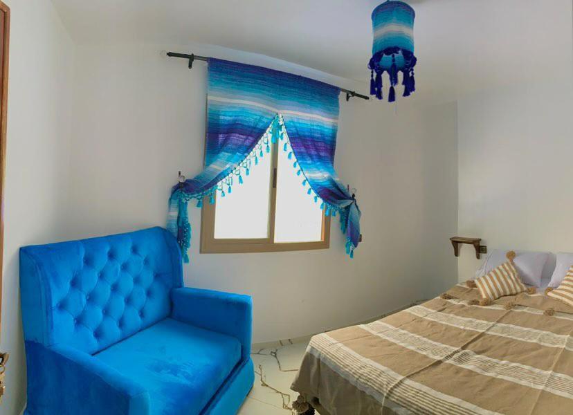 舍夫沙万house naim的一张蓝色椅子,位于带床的房间