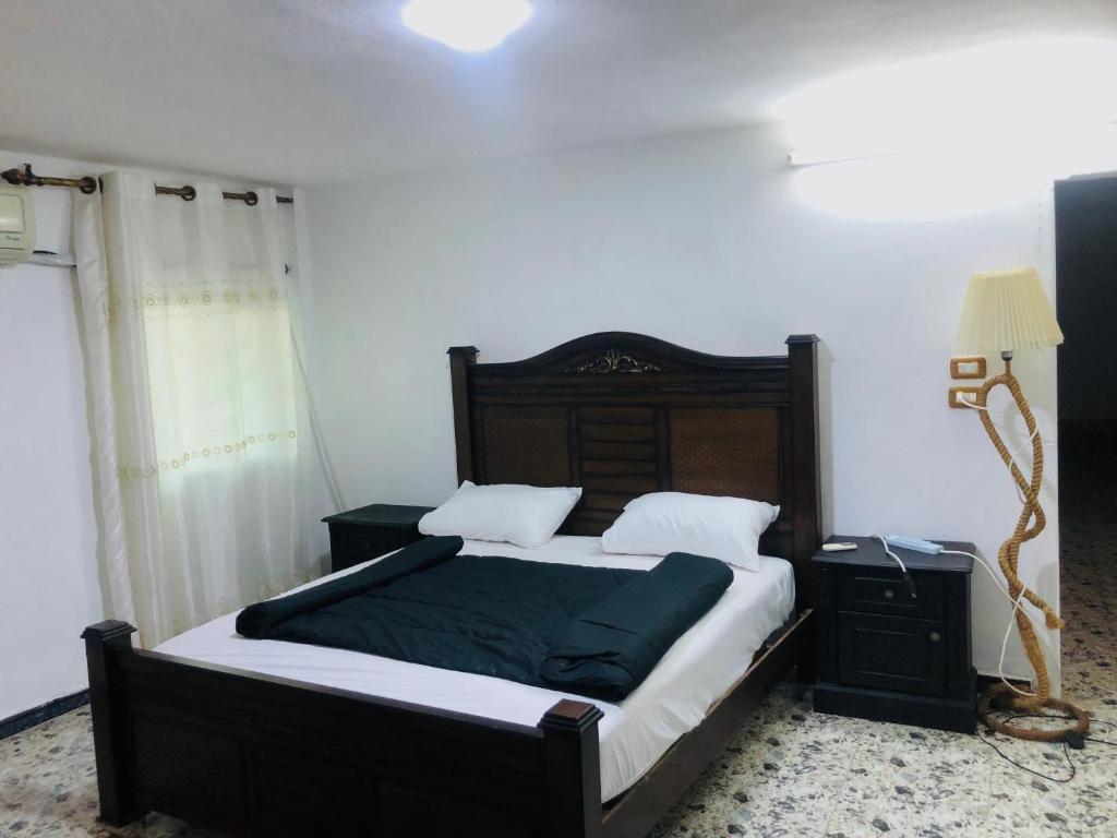 杰拉什Bahaa的一间卧室配有一张大床和木制床头板