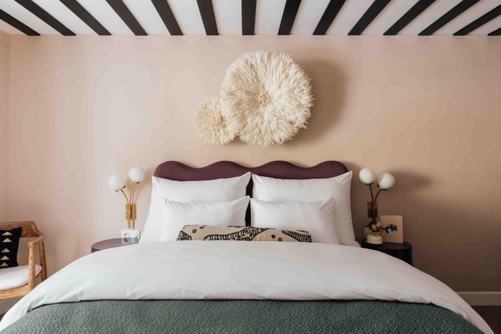 萨尔茨堡Clemonte Hotel - Your Reception-less Boutique Hideaway的一间卧室配有一张带黑白条纹天花板的床