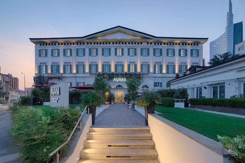 米兰Avani Palazzo Moscova Milan Hotel -Previously NH Palazzo Moscova-的一座白色的大建筑,前面有一条小路