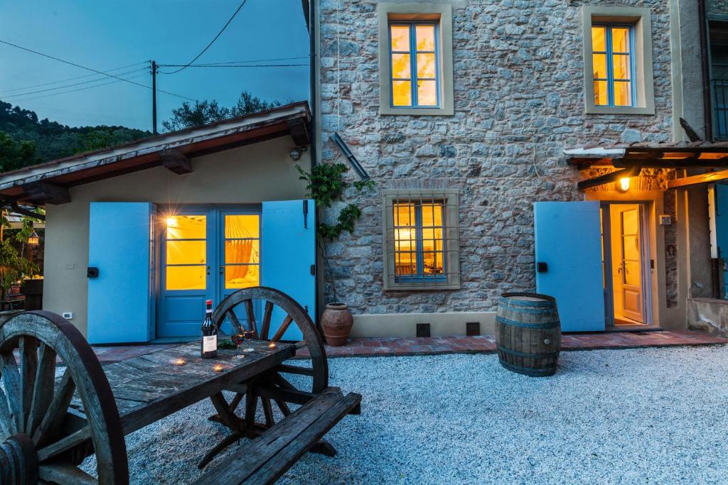 FibbiallaSmart Appart Tuscany的石头房子,设有蓝色的门和木桌