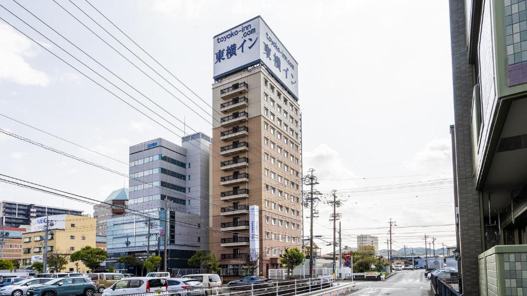 挂川市Toyoko Inn Kakegawa eki Shinkansen Minami guchi的一座高大的建筑,上面有标志