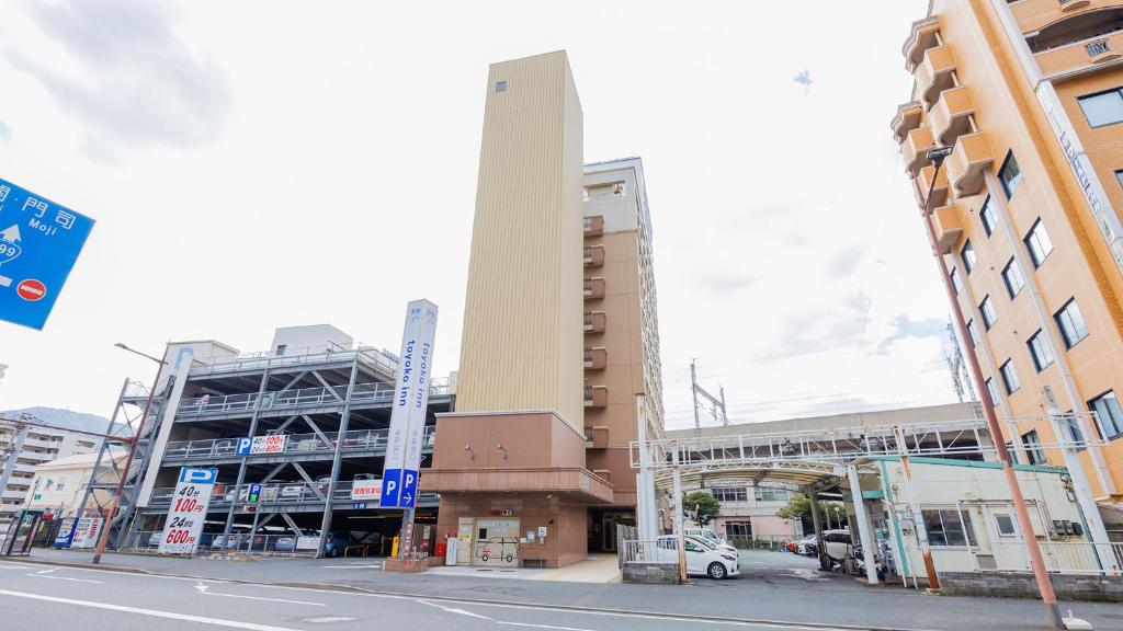 北九州Toyoko Inn Kokura eki Shinkansen guchi的城市街道上一座高大的建筑,有建筑