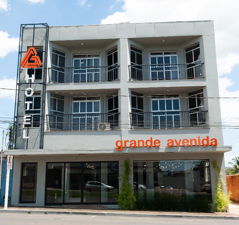 帕特罗西尼乌Grande Avenida Hotel的一座大型白色建筑,设有车库