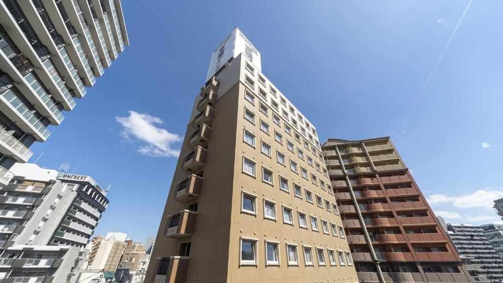 福冈Toyoko Inn Fukuoka Tenjin的建筑中间的高楼