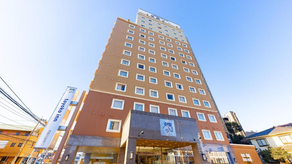相模原市Toyoko Inn Yokohama-sen Fuchinobe-eki Minami-guchi的前面有标志的高楼