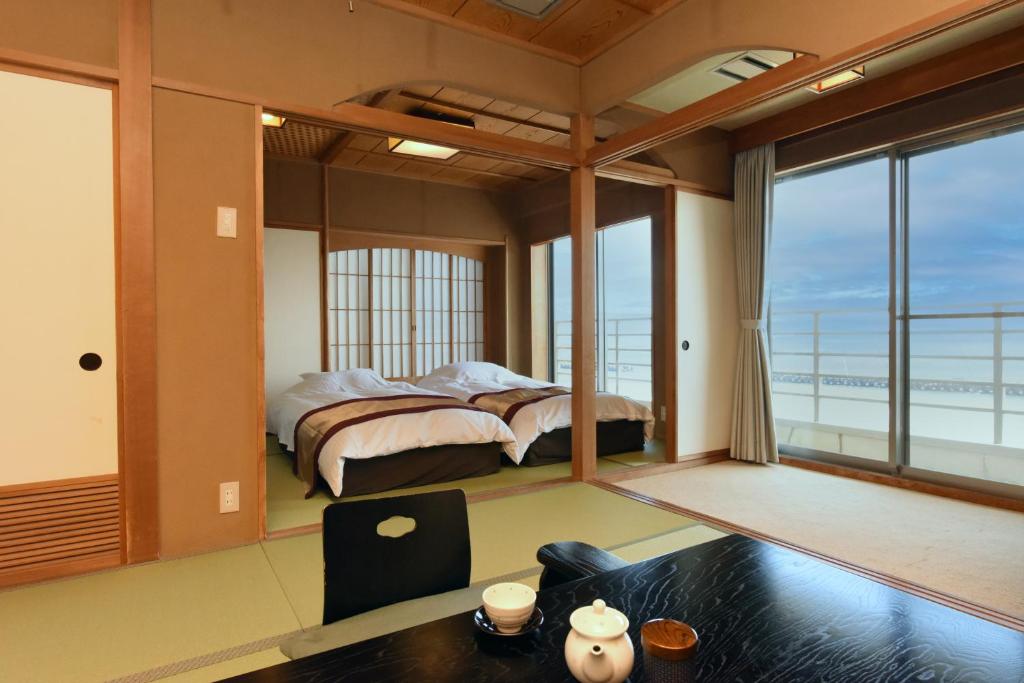 河津町Kaiyutei的一间卧室配有一张床,享有海景